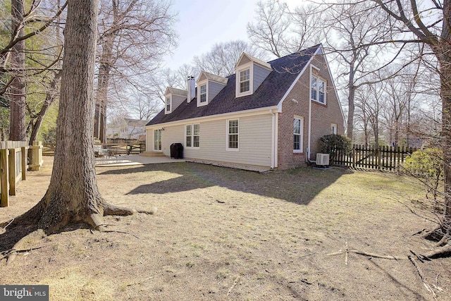 rear view of property featuring brick siding, central AC unit, a patio area, and fence private yard