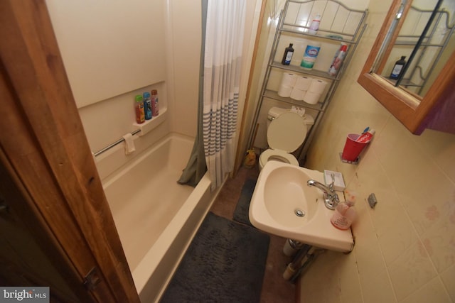 full bathroom with tile walls, a sink, and a shower with shower curtain