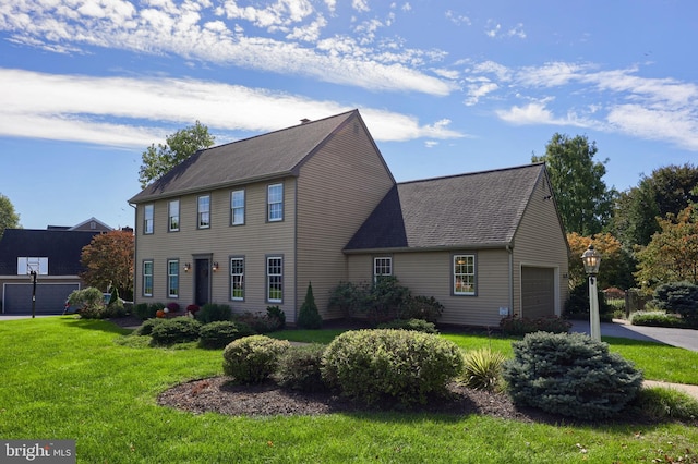 colonial house with a garage and a front yard