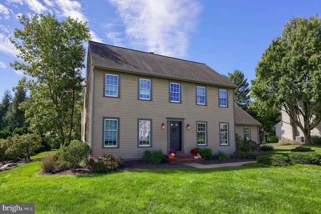 colonial-style house featuring a front lawn