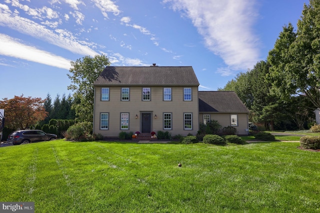 colonial inspired home with a front lawn