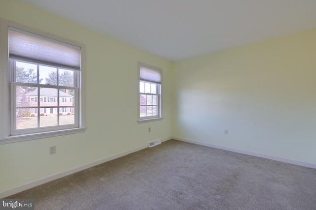 unfurnished room featuring light carpet