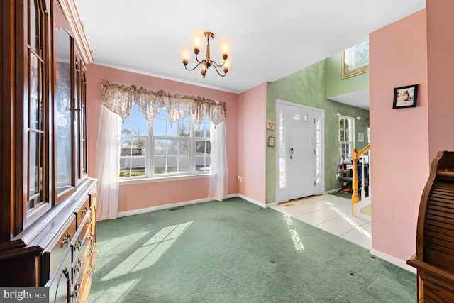 carpeted foyer featuring a notable chandelier