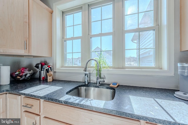 kitchen featuring a sink, dark countertops, and light brown cabinets