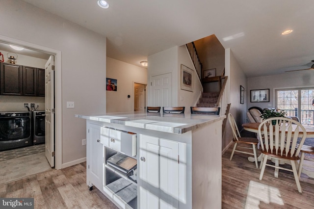 kitchen featuring recessed lighting, light wood-style floors, light countertops, and washer and clothes dryer