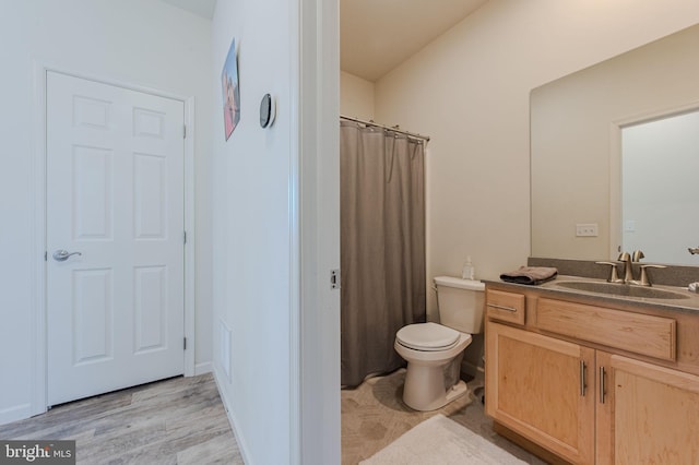 bathroom with toilet, vanity, a shower with curtain, and wood finished floors