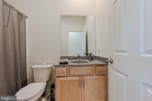 bathroom featuring a shower with shower curtain, toilet, and vanity