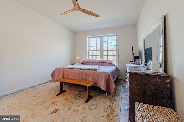 bedroom featuring ceiling fan, baseboards, and wood finished floors