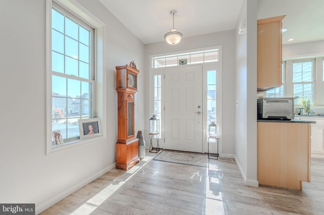 foyer with recessed lighting, baseboards, and light wood finished floors