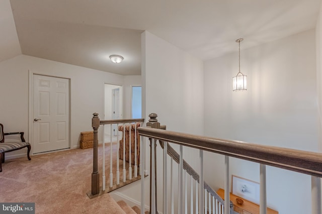 hall featuring an upstairs landing, lofted ceiling, and carpet