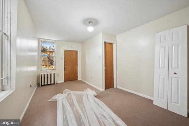 bedroom with radiator and light colored carpet