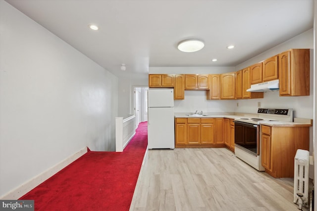 kitchen featuring sink, radiator heating unit, white appliances, and light hardwood / wood-style floors