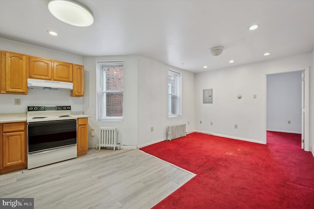 kitchen with white electric stove, light colored carpet, radiator heating unit, and electric panel