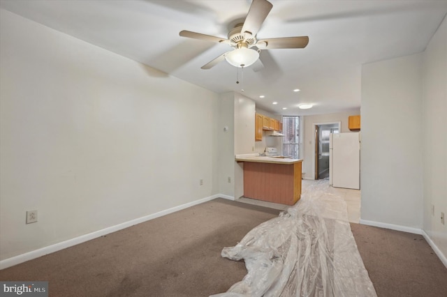 kitchen with white refrigerator, light carpet, ceiling fan, and kitchen peninsula