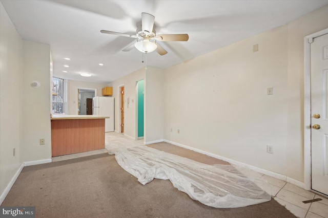 interior space with ceiling fan and light colored carpet