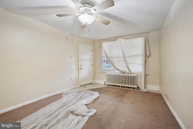 carpeted spare room featuring radiator and ceiling fan