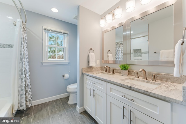 full bathroom featuring vanity, shower / bath combo with shower curtain, and toilet