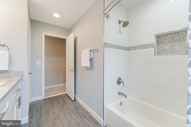 bathroom with tiled shower / bath and vanity