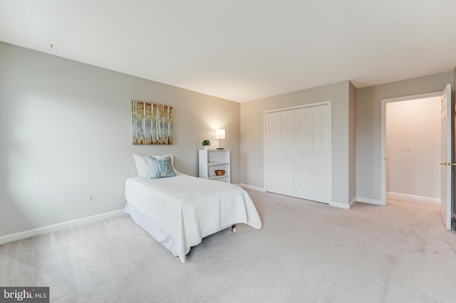 bedroom featuring light carpet and a closet