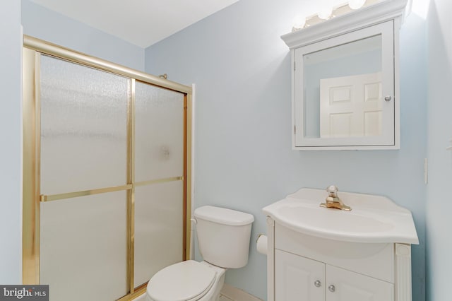 bathroom featuring vanity, toilet, and a shower with shower door