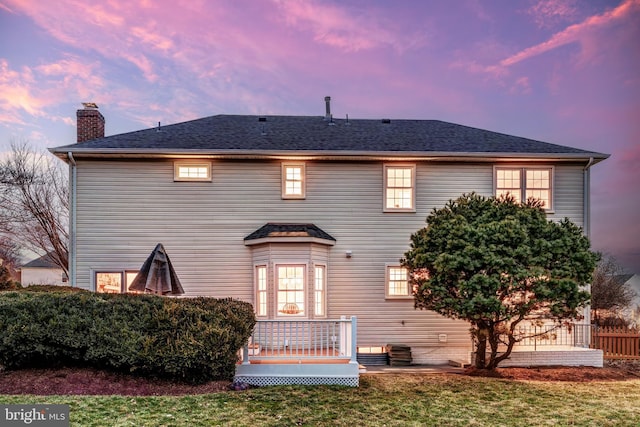 view of front of property featuring a wooden deck and a yard