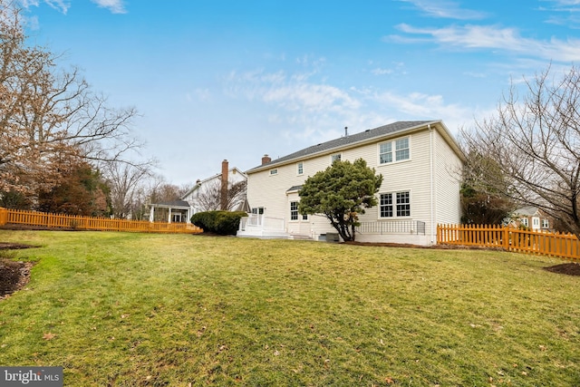 rear view of house featuring a yard