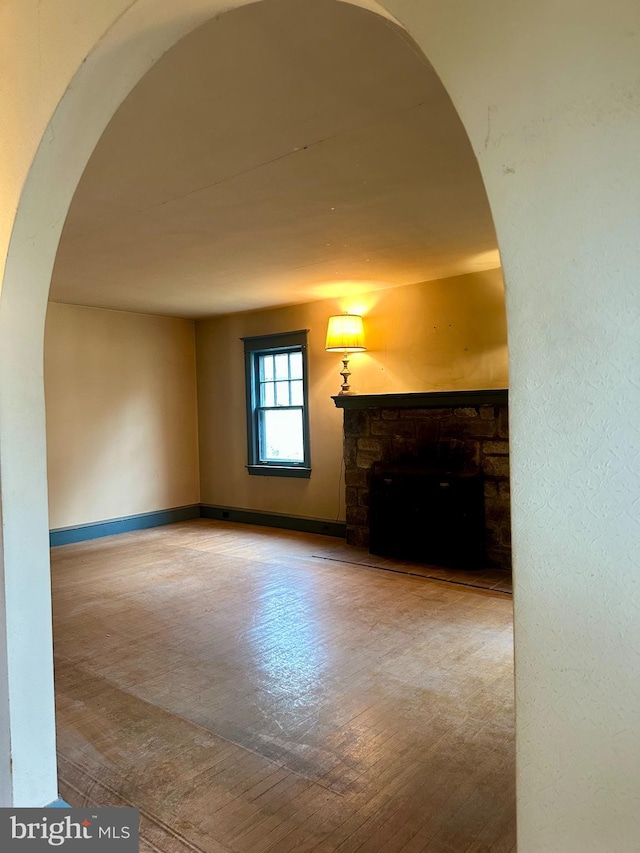 unfurnished living room featuring a stone fireplace