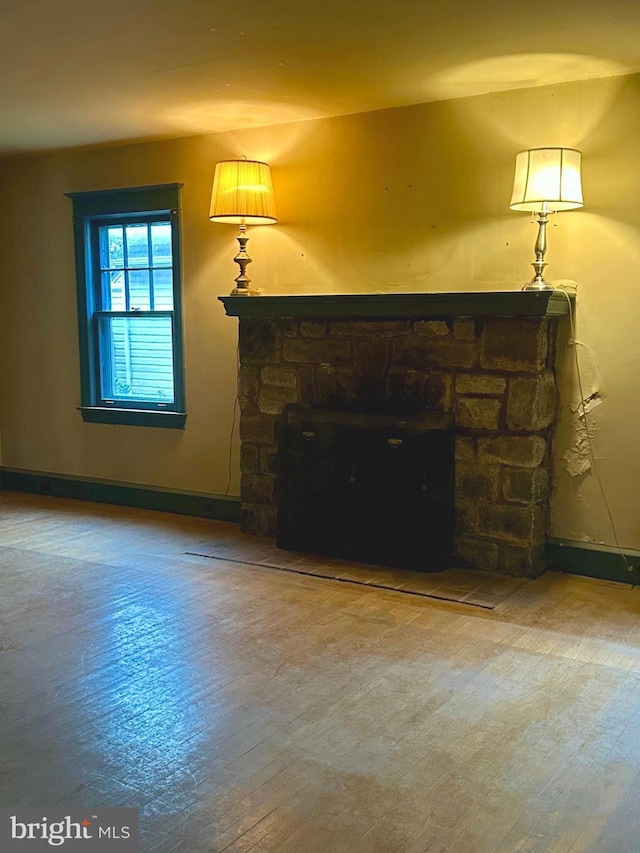 living room featuring a stone fireplace and hardwood / wood-style flooring