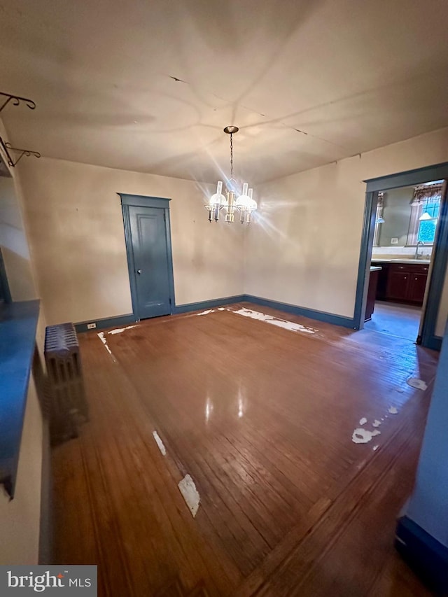 unfurnished dining area featuring an inviting chandelier and dark hardwood / wood-style floors