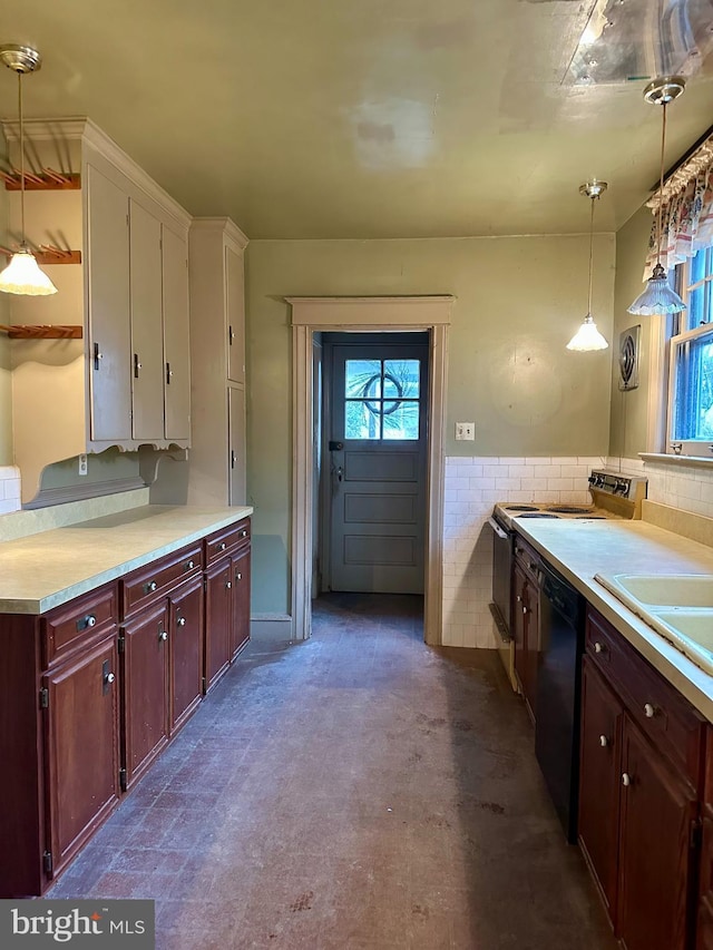 kitchen featuring plenty of natural light, black dishwasher, tile walls, and decorative light fixtures