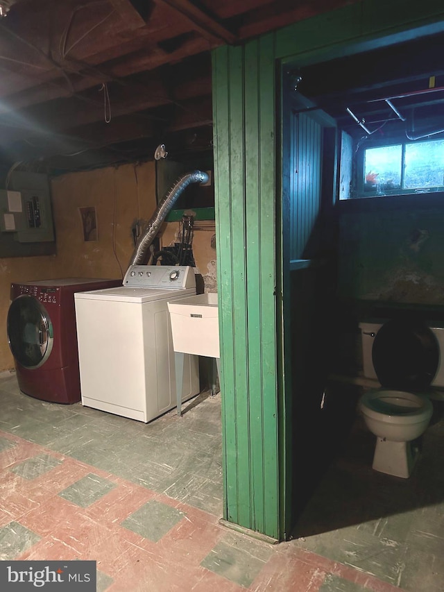 washroom featuring sink, washing machine and clothes dryer, and electric panel