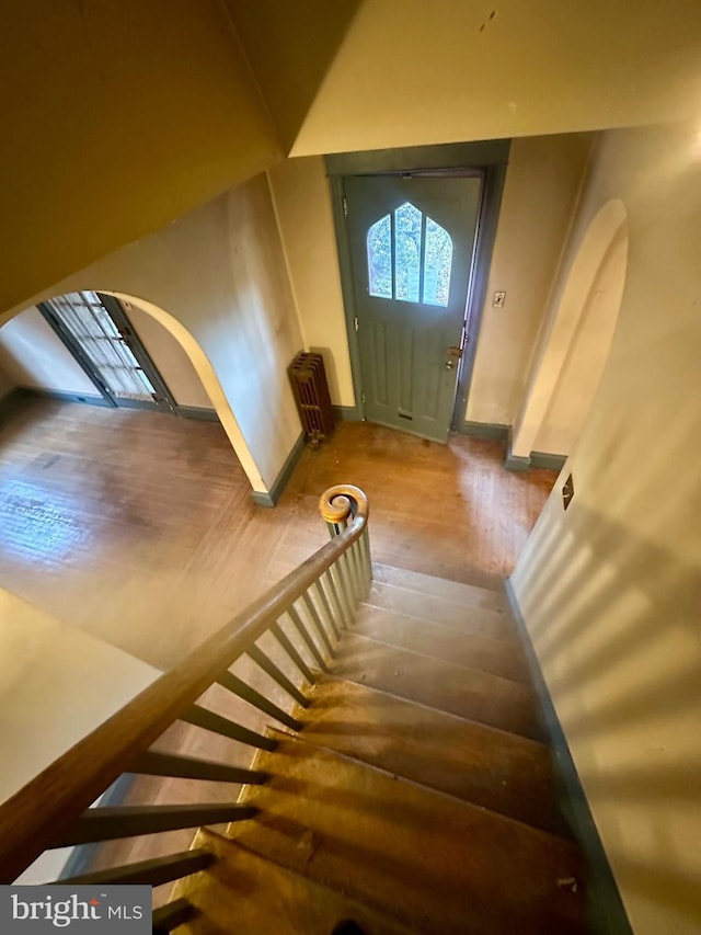 entryway with radiator and hardwood / wood-style floors