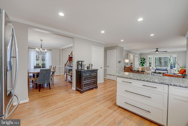 kitchen with stainless steel refrigerator with ice dispenser, light hardwood / wood-style flooring, a healthy amount of sunlight, light stone countertops, and white cabinets