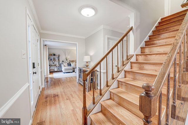 entryway featuring ornamental molding and light wood-type flooring