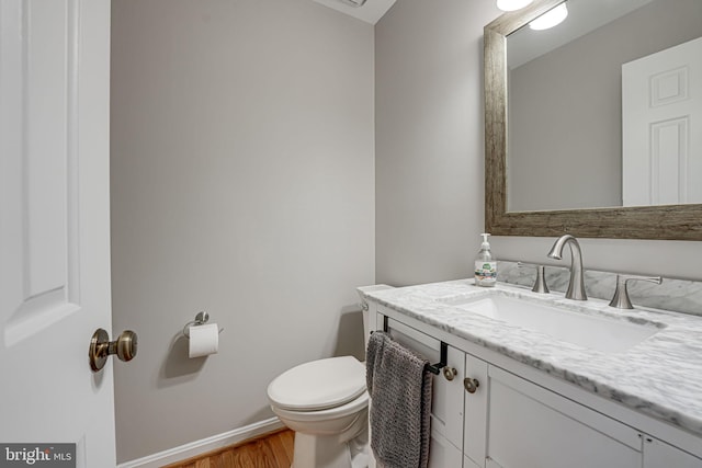 bathroom featuring vanity, wood-type flooring, and toilet