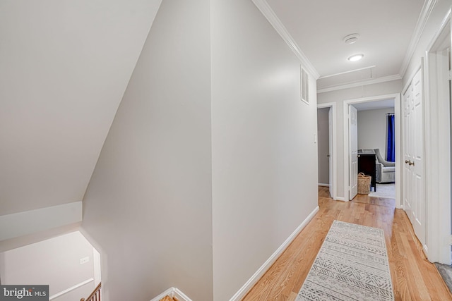 hallway with crown molding and light hardwood / wood-style flooring