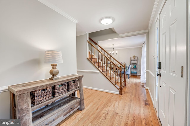 entryway featuring crown molding, light hardwood / wood-style floors, and a notable chandelier