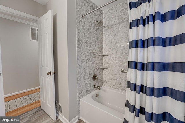 bathroom featuring hardwood / wood-style flooring and shower / bathtub combination with curtain