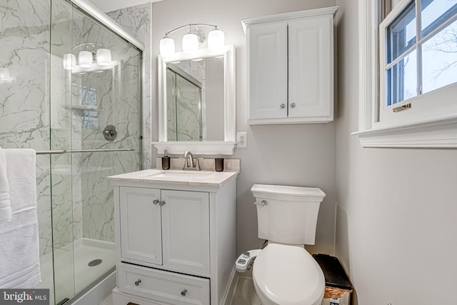 bathroom with vanity, toilet, and a shower with door