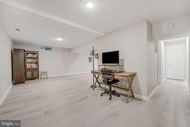 home office featuring light hardwood / wood-style flooring and a textured ceiling