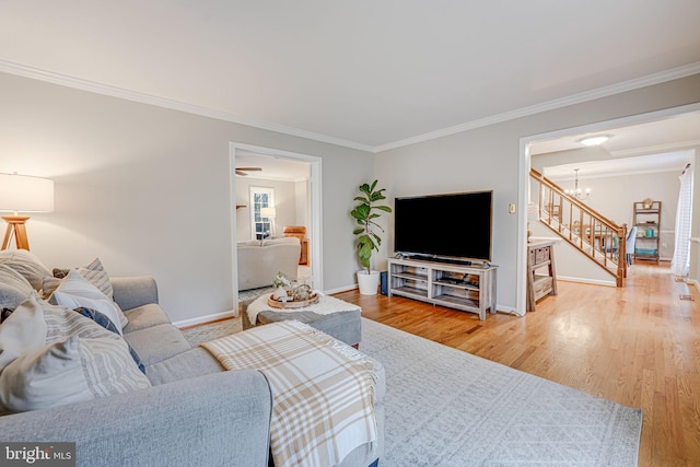 living room featuring an inviting chandelier, crown molding, and hardwood / wood-style floors