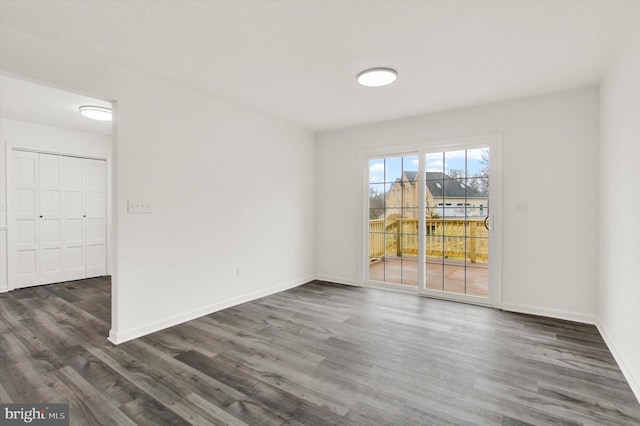 unfurnished room with dark hardwood / wood-style flooring