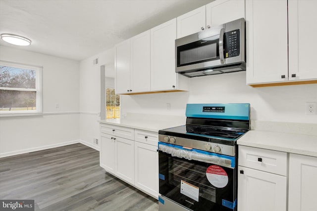 kitchen with white cabinetry, dark hardwood / wood-style flooring, and stainless steel appliances