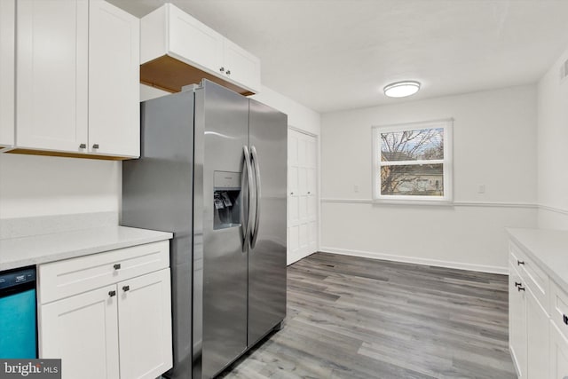 kitchen featuring stainless steel refrigerator with ice dispenser, dishwasher, and white cabinets