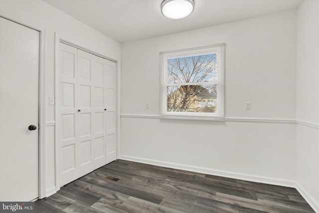 interior space with dark wood-type flooring and a closet