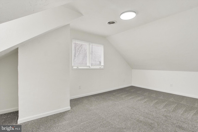 bonus room featuring vaulted ceiling and dark colored carpet