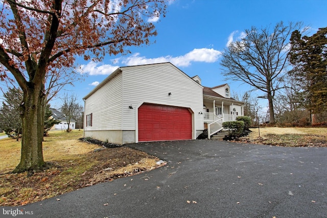 view of side of home featuring a porch and a garage