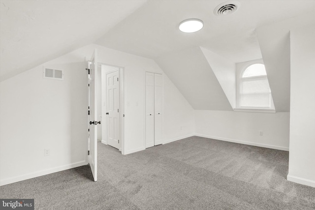 additional living space featuring lofted ceiling and carpet