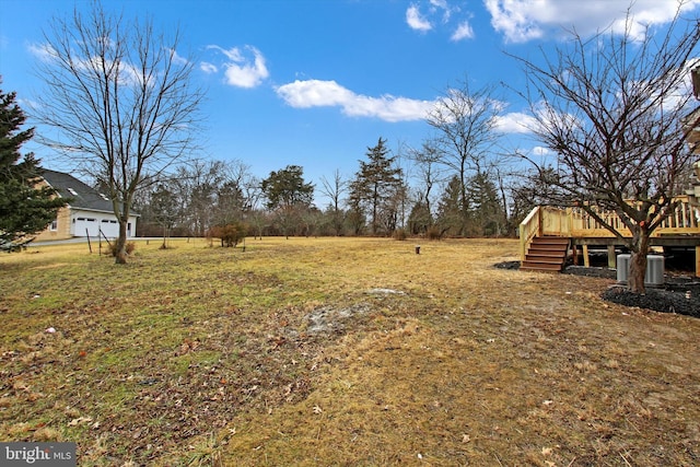 view of yard with a wooden deck and central AC unit