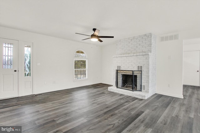 unfurnished living room featuring ceiling fan, dark wood-type flooring, and a fireplace